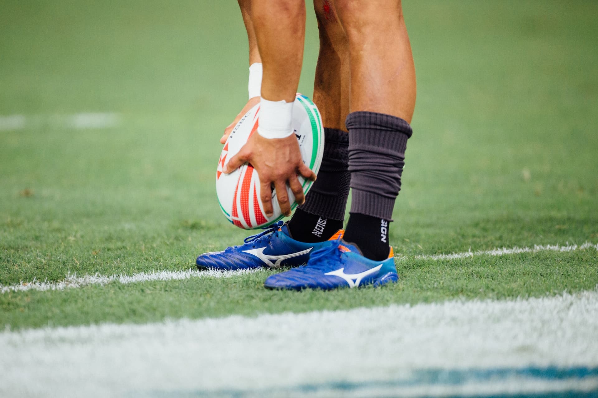 pieds avec ballon de rugby sur un terrain