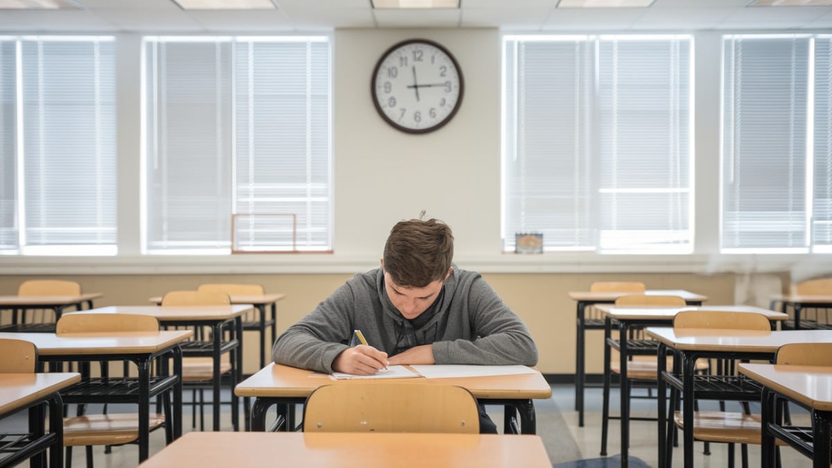 Étudiant écrivant en classe